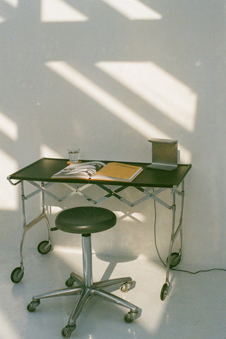 Desk with chair, book, and glass on a white background.