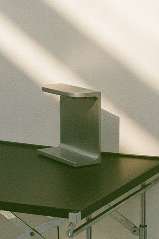 Metal side table on a dark green surface.