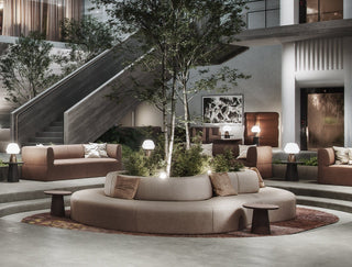 Lobby with seating, trees, and staircase.