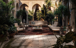 Courtyard with seating, plants, and arched architecture.