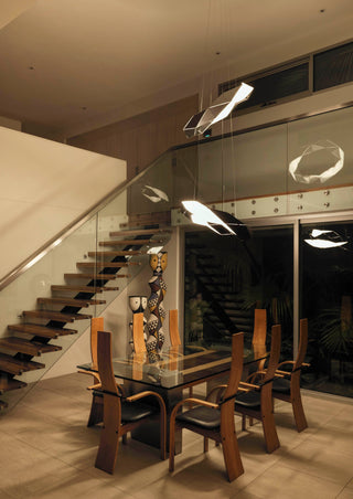 Modern dining room with sculptural lighting and stairs