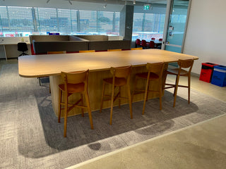Long wooden table with chairs in a modern office setting