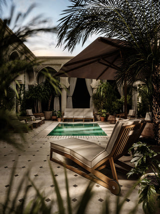 Courtyard with pool, lounge chairs, and palm trees.