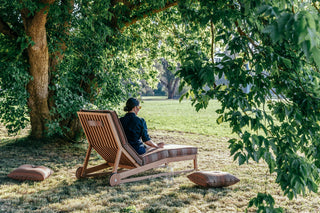 Didier TanGuor relaxing in a chair under a tree