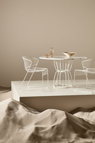 ND chairs and table against a beige wall.