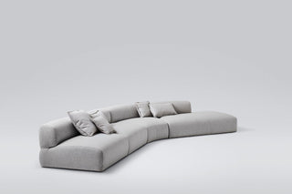 Gray curved sectional sofa with pillows.