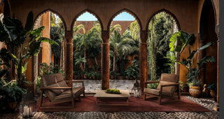 Courtyard with seating and arched openings to garden.