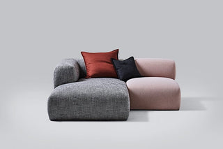 Modern modular sofa with red and black pillows.