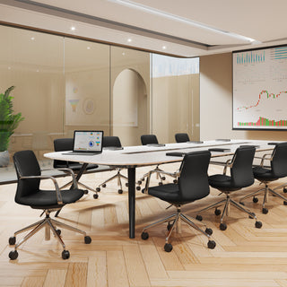 Modern conference room with a long table and black chairs, featuring a large screen displaying graphs.