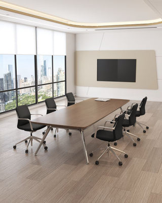 Modern conference room with a large wooden table and black chairs, featuring a cityscape view through large windows.