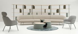 Modern living room with a beige sofa, gray chairs, and a coffee table on a white floor.