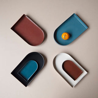 Four colorful trays with orange fruit