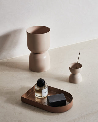 Modern bathroom decor with tray, soap, perfume, and vases.