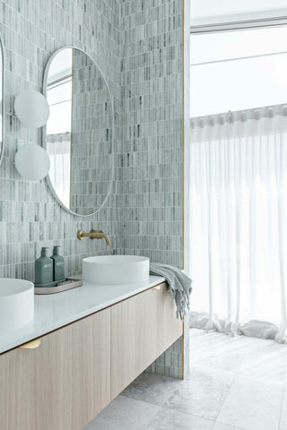 Modern bathroom with oval mirror and tiled wall