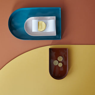 Arc-shaped trays with decorative items on colorful background