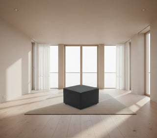 Black cube-shaped ottoman on a white background