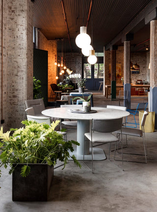 Caterpillar table in Ultimo restaurant, surrounded by chairs and plants