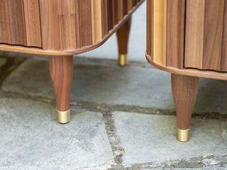 Wooden cabinet legs with brass tips.