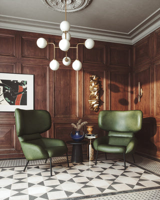 Green wingback chairs in a wood-paneled room