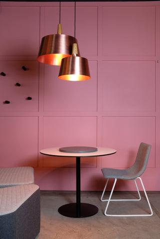 Copper pendant lights over a modern dining table