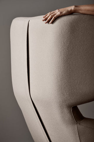 Detail of upholstered chair with hand resting