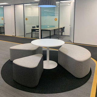 Modern office meeting area with round table and seating