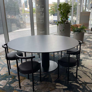 Discus-18 table with black chairs in a modern office setting.