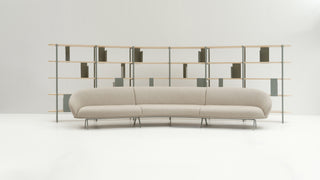 Beige sofa in front of a modern bookshelf against a white wall