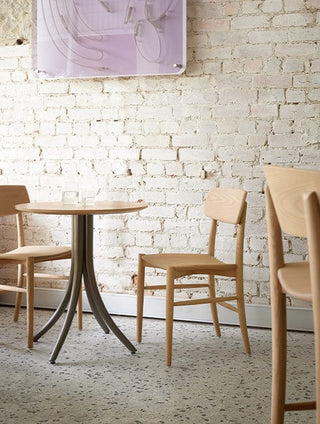 Cafe table and chairs against white brick wall