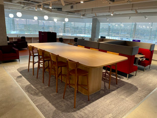 Long wooden table with chairs in a modern office setting