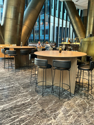 Bar area with stools and round tables.
