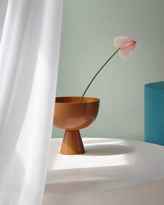 copper bowl with pink flower on white table