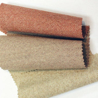 Rolled fabric swatches in red, tan, and beige