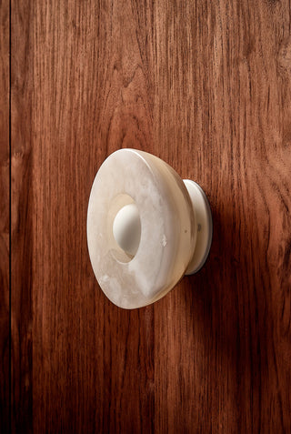 Marz Designs Aurelia Surface Sconce in White Onyx, mounted on wood.