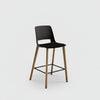 Bar stool with black seat and wooden legs on a white background