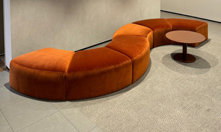 Orange curved sofa with small table, photo from March 7, 2025.
