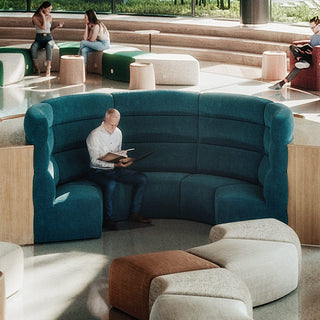 Puffalouniversalcurvedinner highback sofa with people in a modern lounge