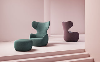 Two modern armchairs and ottoman in pink room