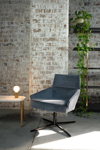 Wall-st modern chair with lamp and plant against brick wall