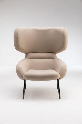 Beige upholstered armchair on black legs.