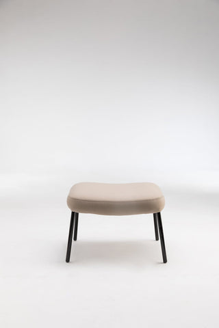 Beige upholstered footstool with black legs.