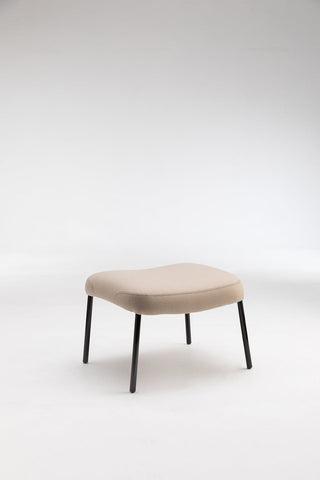 Beige upholstered footstool with black legs.