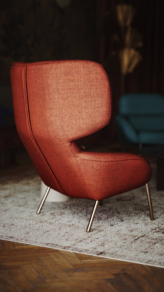 Red upholstered armchair with metal legs.