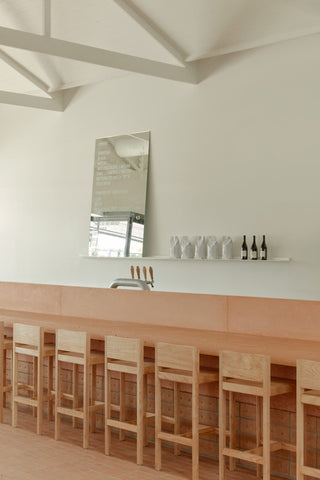 Bar with stools, mirror, and bottles.