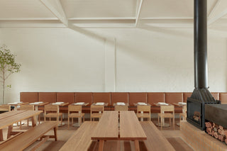 Restaurant interior with tables and fireplace.