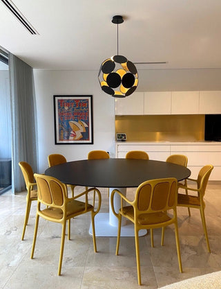 Dining room with round table and yellow chairs.