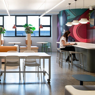 Office space with seating and a person working.