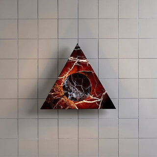 Triangular artwork with marble-like texture on tiled wall.