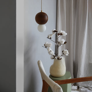 BrightBeads sphere pendant light in situ with cotton branch and chair.