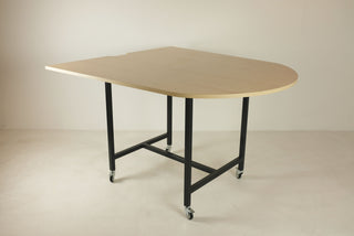Modern semi-circle table with black legs on wheels.